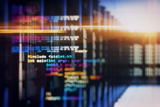 A stylised image of multicoloured computer code overlaying a picture of server racks in a datacentre