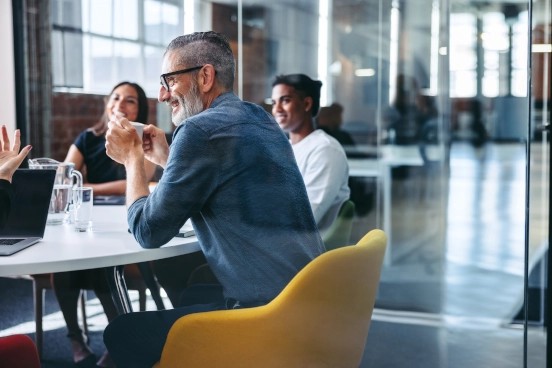 A picture of three people working around a desk