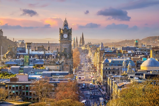 An image of Princes Street in Edinburgh stretching into the distance taken from a high vantage point at the southern end of the street.